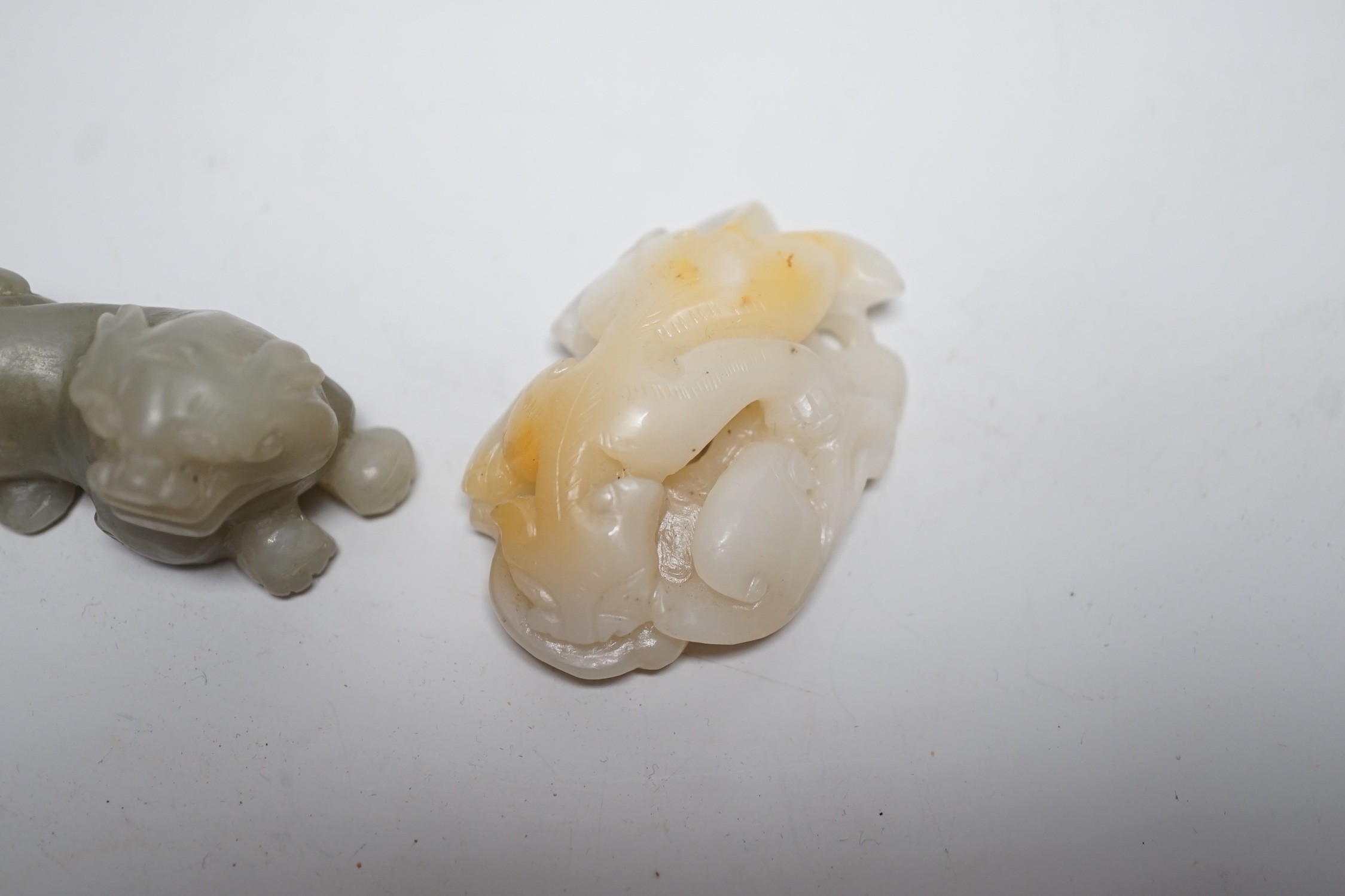 A Chinese white and russet Jade chilong carving and a celadon jade figure of a lion-dog, 7cm